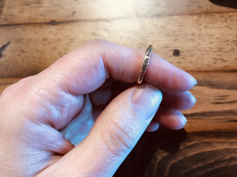 a wedding ring on an index finger.