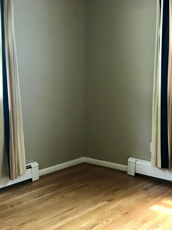 a corner of a room with wood floors.