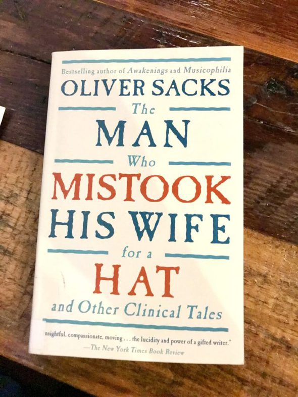 An Oliver Sacks book on a wood table.