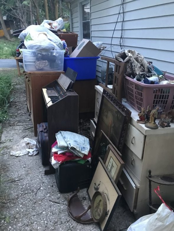 piles of junk outside a house.