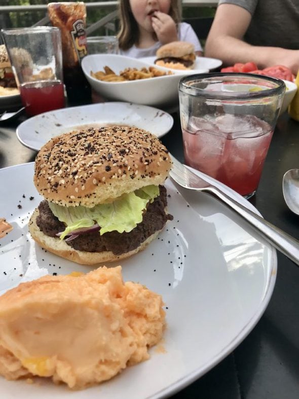 A burger on a white plate.