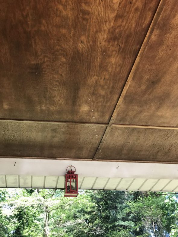 a red lantern hanging in a carport.