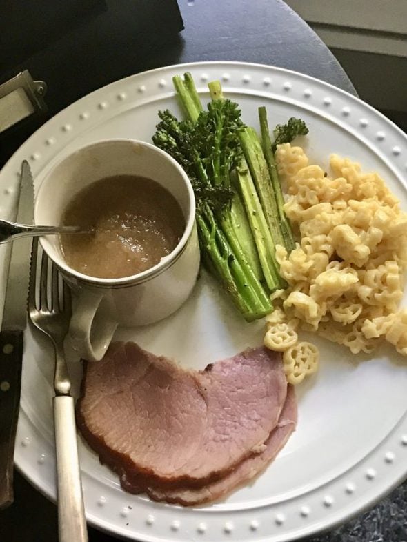 A plate with ham, applesauce, mac and cheese, and broccoli.