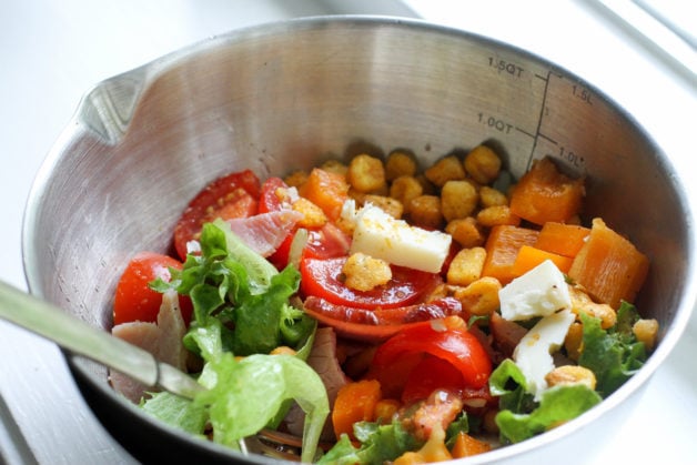 A green salad in a metal bowl.