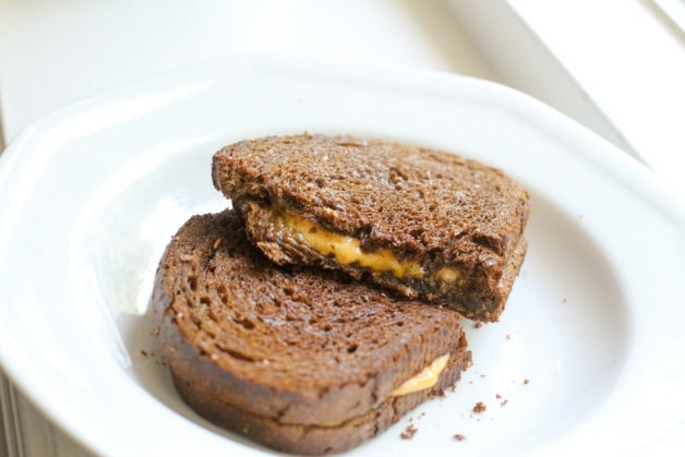 Grilled cheese sandwich on white plate.