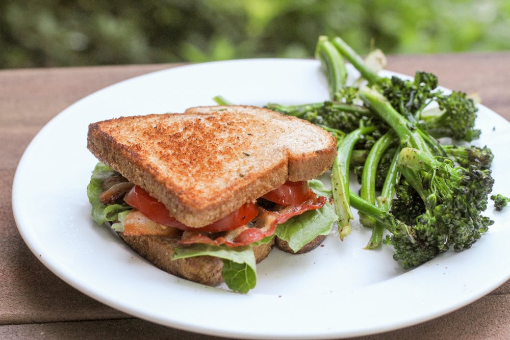 BLT and broccoli on a white plate.