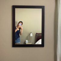 Kristen shown in a reflection in a wall mirror.