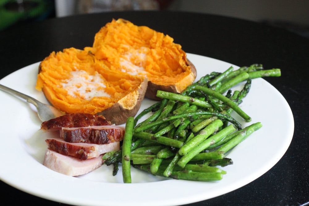 Ham, asparagus, sweet potato on white plate.