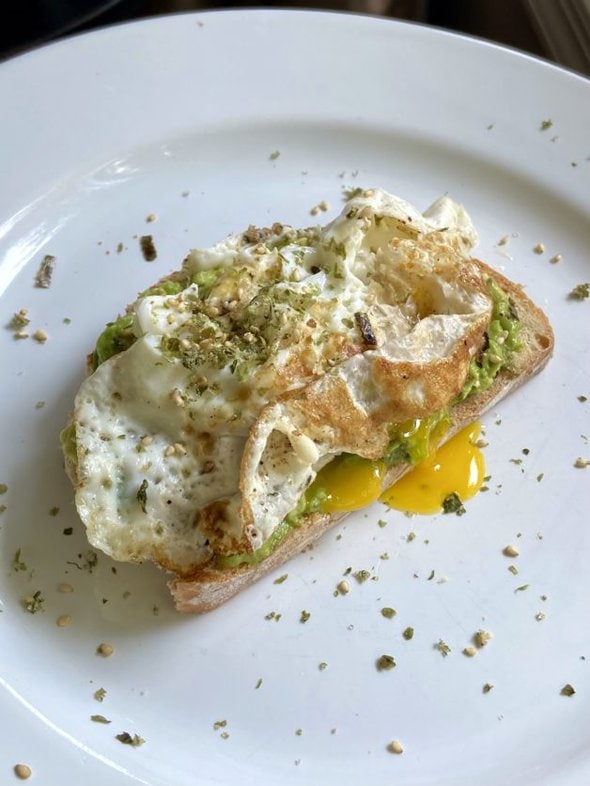 Avocado toast on white plate.