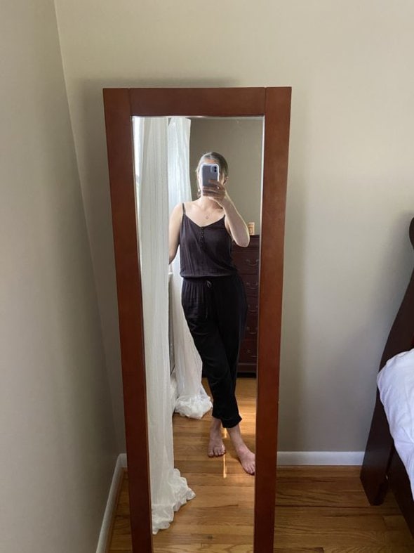Kristen in a mirror selfie, wearing a jumpsuit.