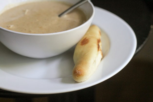 crab soup with a breadstick on the side.