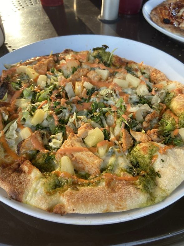 Pizza topped with greens.