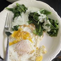 eggs and spinach in a white bowl.