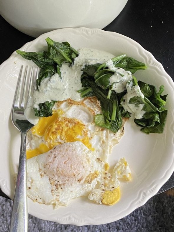 eggs and spinach in a white bowl.