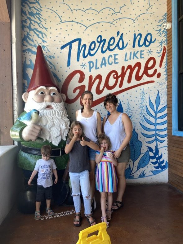 Kristen and her friend next to a gnome.