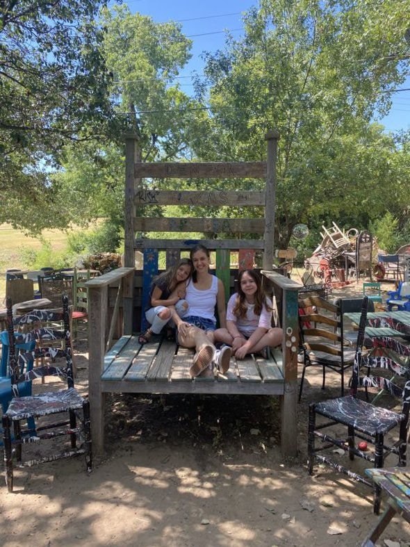 Kristen sitting in a huge chair with two girls.