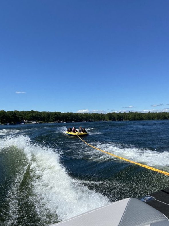 girls tubing behind a boat.