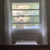 an open window with white curtains.