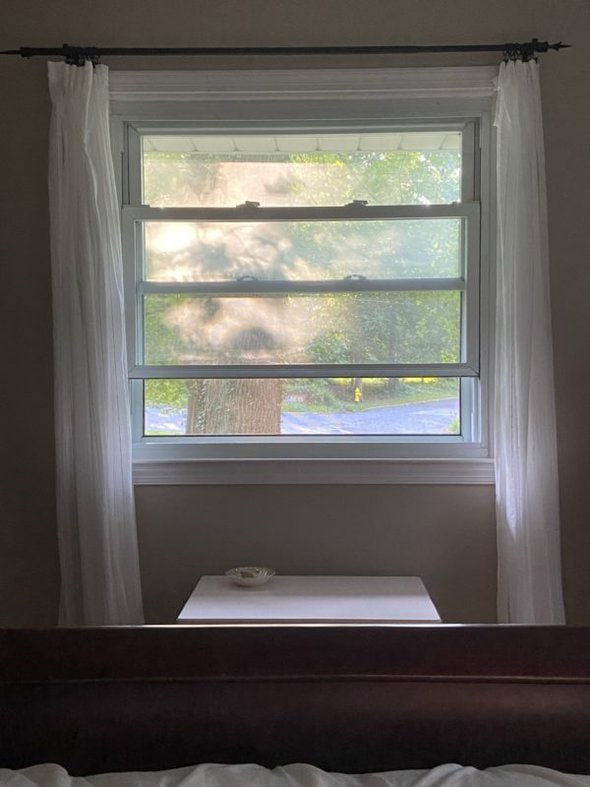 an open window with white curtains.