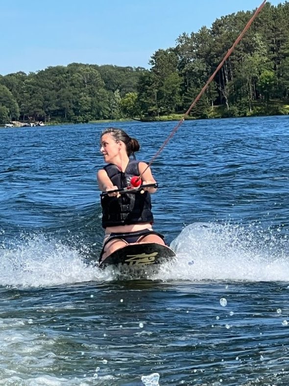 Kristen riding a knee-board.