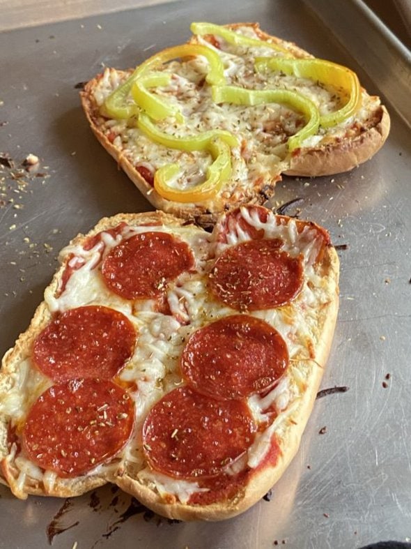Two pizza subs on a baking sheet.