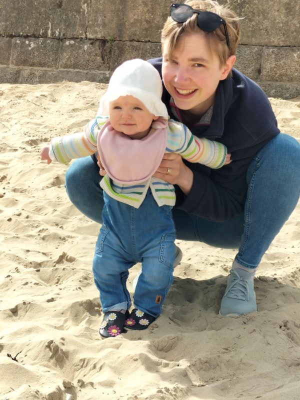 Reader with her daughter in the sand.