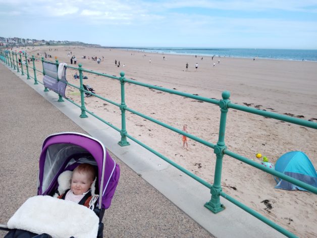 baby in a stroller by the beach.