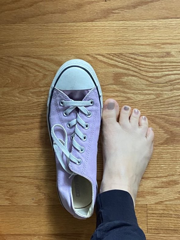 Kristen's foot next to a too-big pair of converse.