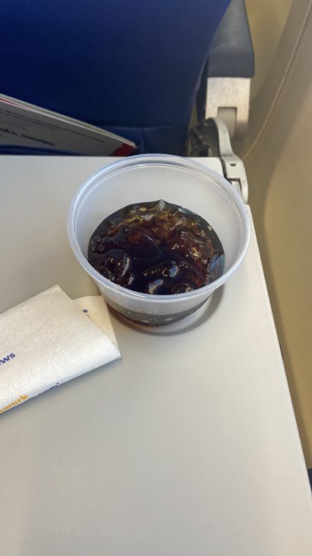 cup of coke on tray table.