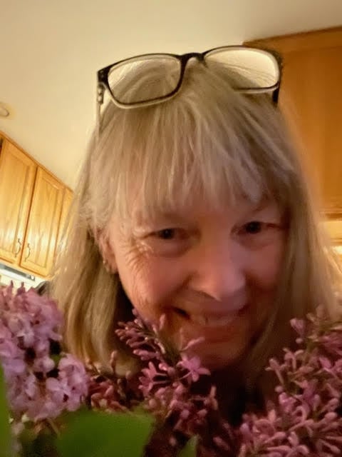 jean next to pink flowers.