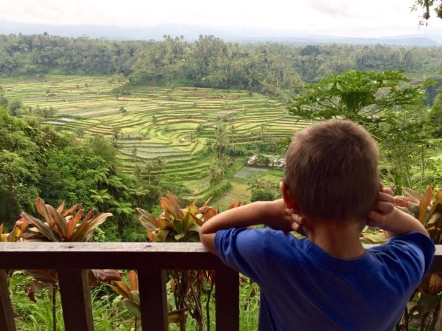 child looking over railing in Bali.