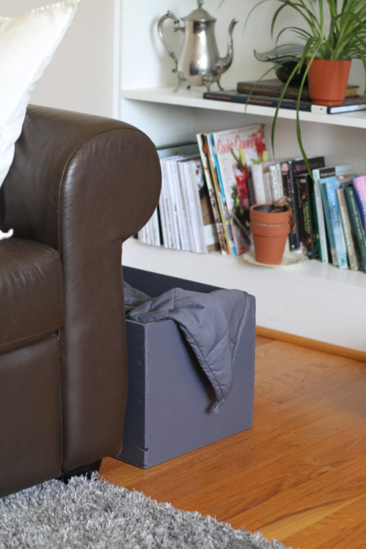 crate next to brown sofa.