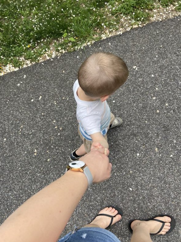 Kristen holding hands with a toddler.