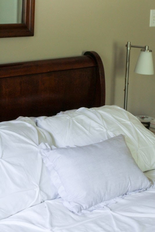 wood sleigh bed with white bedding.