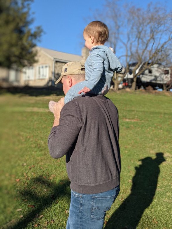 dad with a toddler on his shoulders.