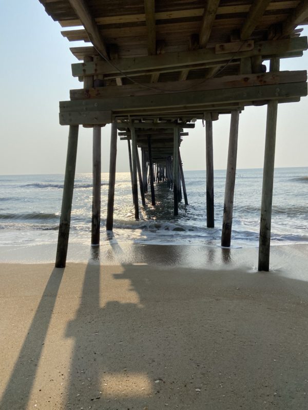 view under a pier at the ocean.