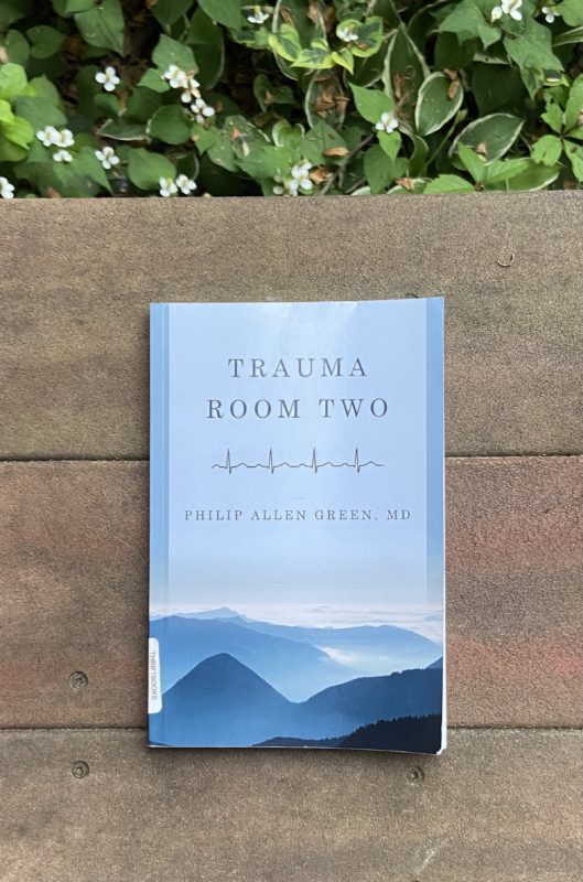 trauma room two book cover on a bench.