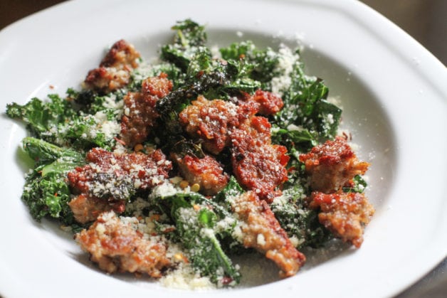 sausage and kale on a white plate.