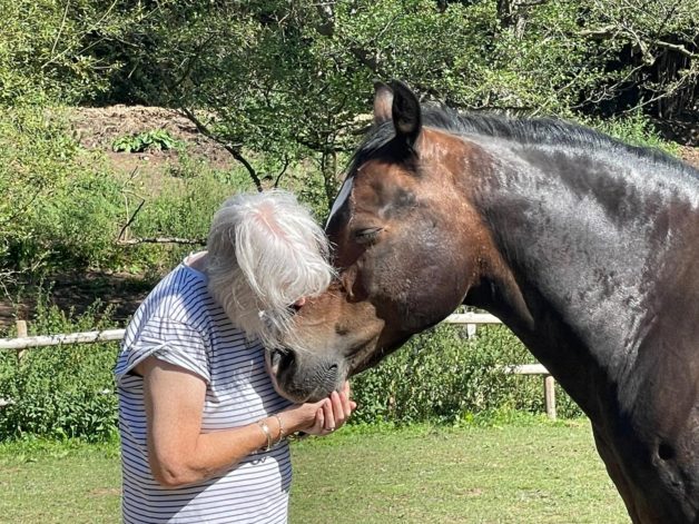Julie hugging a horse.