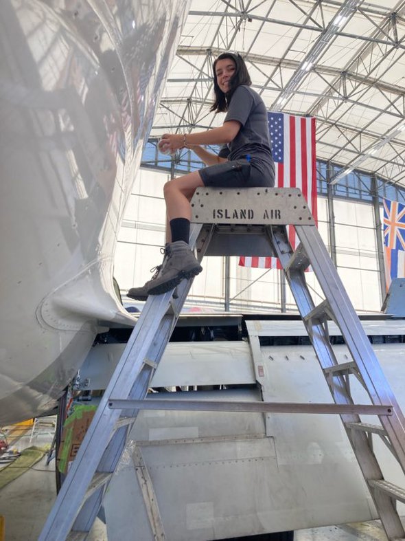 Lisey on a ladder by a plane.