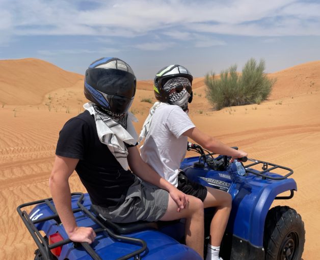 teen boys on an ATV in a desert.