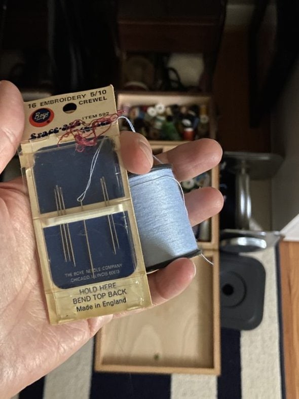 needle packet and spool of blue thread.