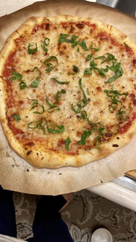 cheese pizza sprinkled with basil.