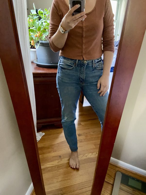 Kristen in jeans and a brown shirt.