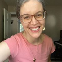 Kristen in a pink shirt with a larger neckline.