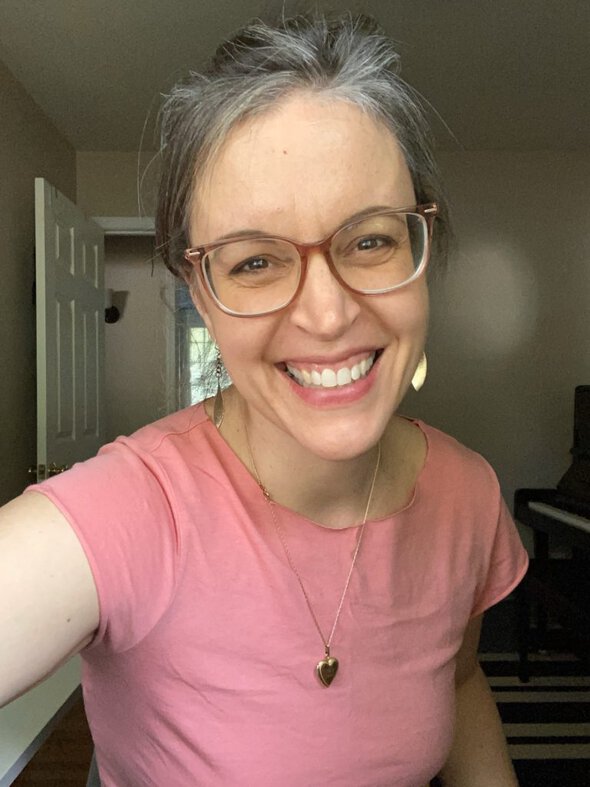 Kristen in a pink shirt with a larger neckline.