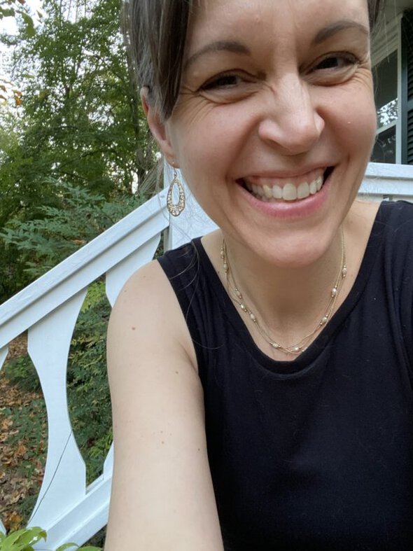 Kristen wearing a black dress and earrings.