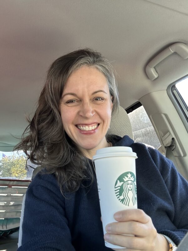 Kristen holding a coffee.