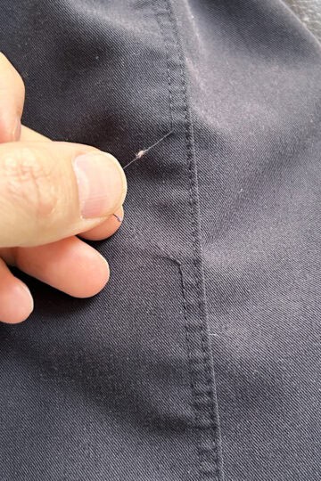 black scrub pants with loose thread.