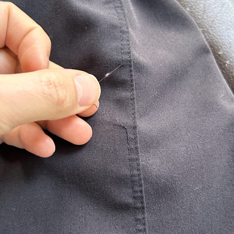 black scrub pants with loose thread.